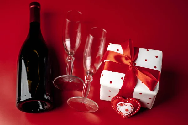 valentines day background. wine bottle, glasses and gift on red background