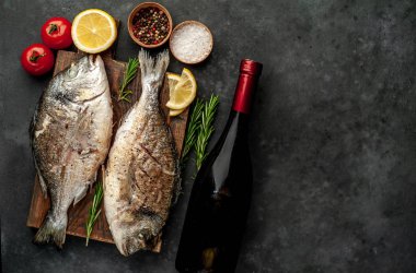 Baharat ve limonla ızgara Dorado balığı ve bir şişe şarap. Metnin için fotokopi alanı var.