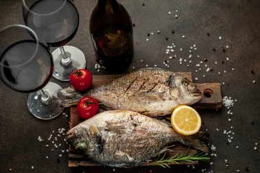 Baharat ve limonla ızgara Dorado balığı ve bir şişe şarap. Metnin için fotokopi alanı var.