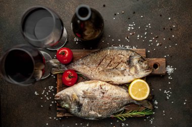 Baharat ve limonla ızgara Dorado balığı ve bir şişe şarap. Metnin için fotokopi alanı var.