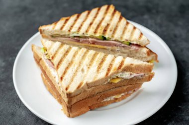 Taş zeminde beyaz bir tabakta lezzetli sandviçler.