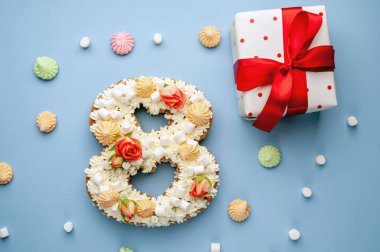 Çiçeklerle süslenmiş 8 numaralı pasta, krem peynir, marşmelov, mavi arka planda Bizet. Uluslararası Kadınlar Günü kartpostalı