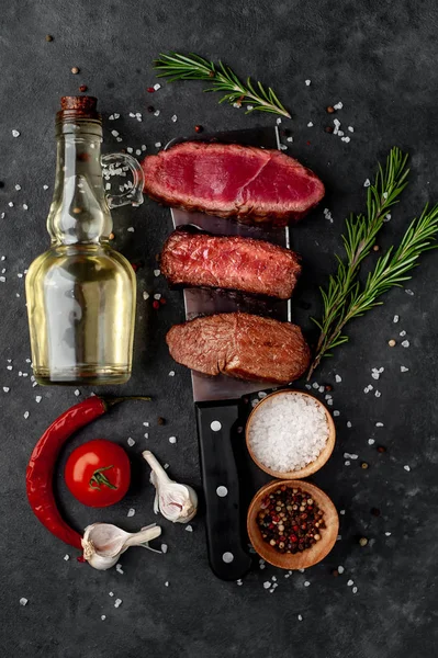 Three pieces of meat grilled over a meat knife Three types of frying meat, rare, medium, well done on stone background with copy space for your text