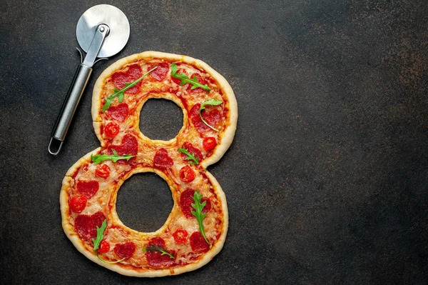 pizza in the form of 8 for International Women's Day on the eighth of March on a stone background with copy space for your text