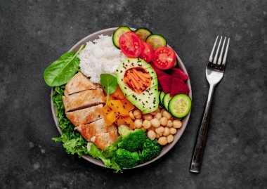 Pilav, tavuk göğsü, brokoli, balkabağı, avokado, nohut, havuç, salatalık, arka planda pancar.