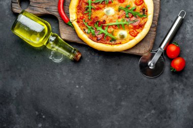 Lezzetli İtalyan pizzası, domates, peynir, bıldırcın yumurtası sosisi ve taş arka planda.