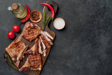 Baharatlı ızgara biftekler taştan bir arka planda kesim tahtasının üzerinde