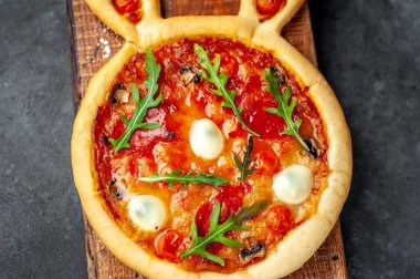 Tavşan şeklinde paskalya pizzası ve arka planda yumurtalar.