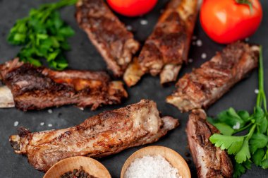 Izgara pirzola, domates ve baharatlı koyu arkaplan.