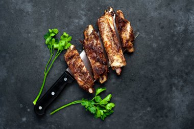 Baharatlı ızgara kuzu kaburgası ve koyu arkaplanda maydanoz.