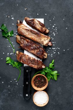 Baharatlı ızgara kuzu kaburgası ve koyu arkaplanda maydanoz.