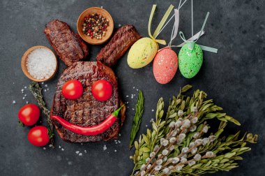 Baharatlı ve renkli yumurtalı ızgara Paskalya bifteği. Taş zemin üzerinde paskalya tavşanı ve metin için kopyalama alanı.