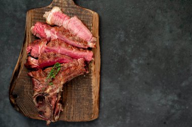 Kırsal masa arka planında ızgara et dilimleri, otlar, tuz ve biber.