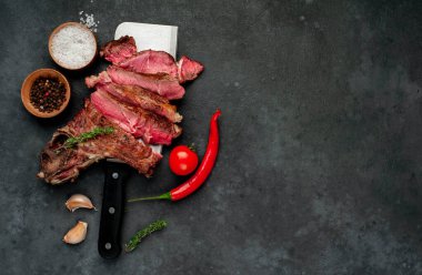 New York usulü ızgara biftek dilimleri, otlar ve domateslerle dolu.