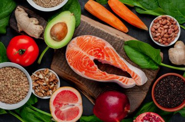 Sebzeli somon balığı çiğ biftek ve kırsal masa arkasında tahıl tabağı olan meyve.