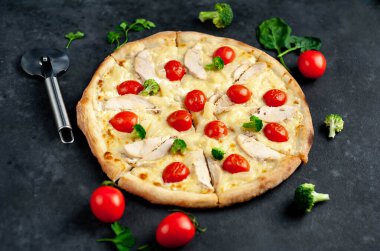 Tavuklu, peynirli ve domatesli ev yapımı pizza dilimleri.