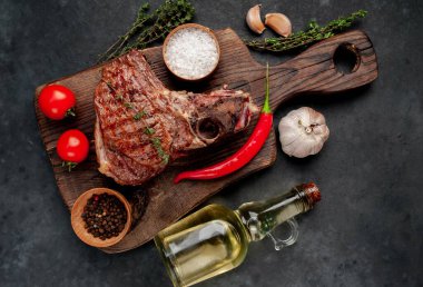 Kahverengi ahşap tahtada biftek ızgara pirzola. Kırsal masa arka planında.