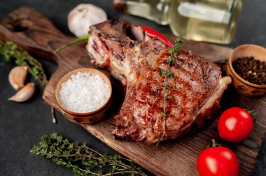 Kahverengi ahşap tahtada biftek ızgara pirzola. Kırsal masa arka planında.