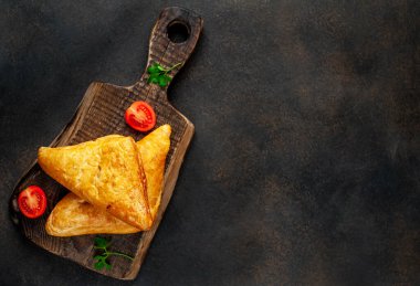 Taze pişmiş üçgen sandviçler et ve peynirli domatesli ahşap tahta dilimler kırsal masa arka planında 