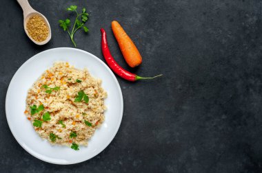 Taze pişmiş bulgur pilavı, sebze ve kır arka planında bitkiler.