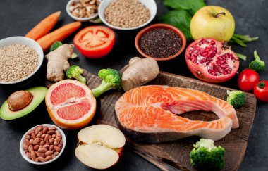 Kırmızı somon bifteği sebzeli ve ahşap tahtada meyveler kırsal masa arka planında