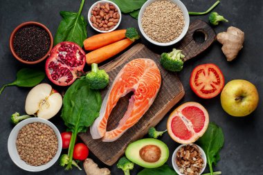 Kırmızı somon bifteği sebzeli ve ahşap tahtada meyveler kırsal masa arka planında