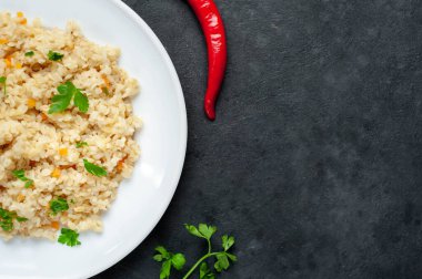 Taze pişmiş bulgur pilavı, sebze ve kır arka planında bitkiler.