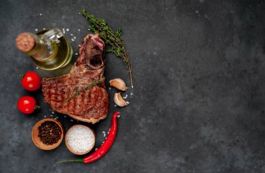 Terbiye edilmiş sebze ezmeli T-Bone bifteği ve domatesli köy masa arkaplanı.