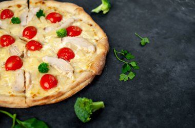 Ev yapımı fırınlanmış pizza dilimlerini kapatıyoruz. Arka planda tavuk eti, peynir ve domates var.