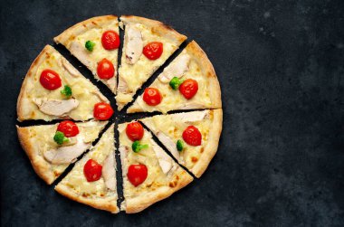 Sıcak ev yapımı pizza dilimleri ile tavuk eti, peynir ve domatesler kırsal masa arka planında