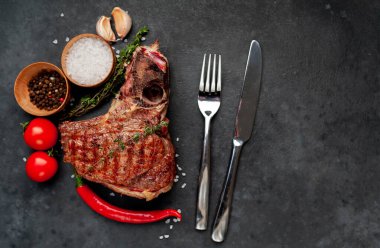 Terbiye edilmiş sebze ezmeli T-Bone bifteği ve domatesli köy masa arkaplanı.