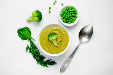 Brokolili krema çorbası ve kırsal masa arkasında yeşil bezelye.