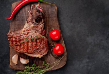 Kahverengi ahşap tahtada biftek ızgara pirzola. Kırsal masa arka planında.