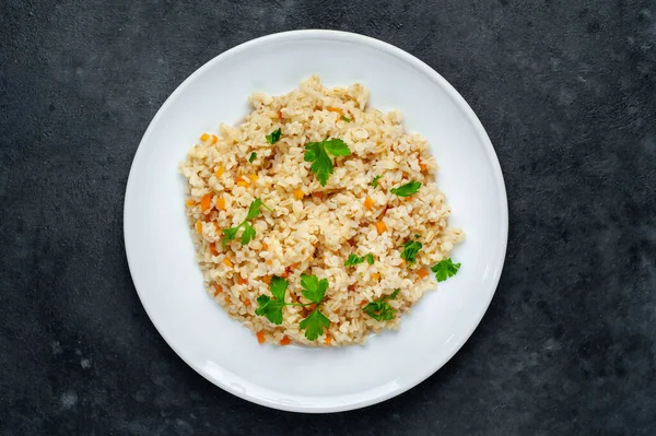 Leckerer Gebackener Reis Mit Karotten Und Petersilie Auf Weißem Teller — Stockfoto