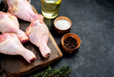 Metnin için kopyalama alanı olan beyaz tabakta baharatlı çiğ tavuk bacağı.