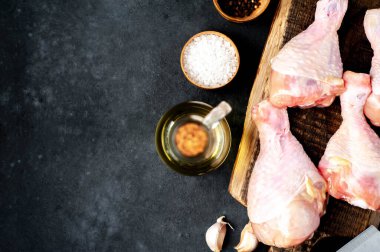 Metnin için kopyalama alanı olan beyaz tabakta baharatlı çiğ tavuk bacağı.