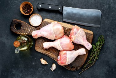 Metnin için kopyalama alanı olan beyaz tabakta baharatlı çiğ tavuk bacağı.