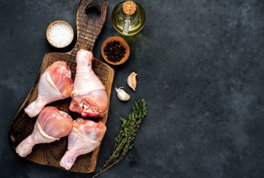 Metnin için kopyalama alanı olan beyaz tabakta baharatlı çiğ tavuk bacağı.