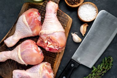 Metnin için kopyalama alanı olan beyaz tabakta baharatlı çiğ tavuk bacağı.