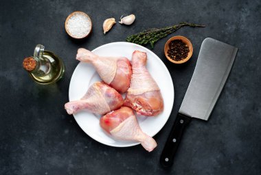 Metnin için kopyalama alanı olan beyaz tabakta baharatlı çiğ tavuk bacağı.