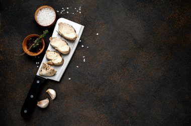 Bıçaklı tavuk göğsü. Arka planda baharatlar var. Metnin için kopyalama alanı var..