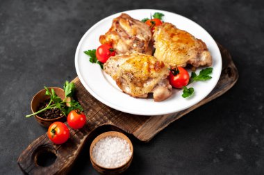 Kesme tahtasında ızgara tavuk butları ve arka planda baharatlar. Metnin için de fotokopi alanı var.