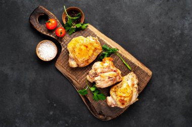 Kesme tahtasında ızgara tavuk butları ve arka planda baharatlar. Metnin için de fotokopi alanı var.