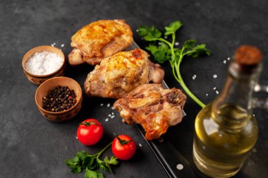 Kesme tahtasında ızgara tavuk butları ve arka planda baharatlar. Metnin için de fotokopi alanı var.