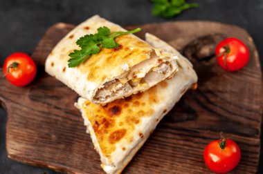 Burrito tavuk ve sebzeyle sarılmış, arka planda beton, Meksika shawarması var.