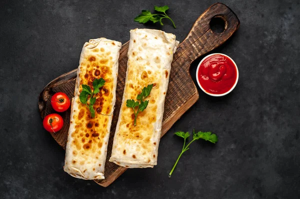 Burrito tavuk ve sebzeyle sarılmış, arka planda beton, Meksika shawarması var.