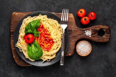 Domates ve fesleğenle servis edilen iştah açıcı makarna.