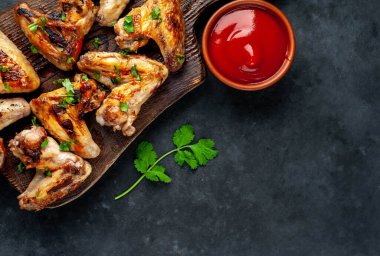 Tahta tahta, kızarmış tavuk kanadı, kurutulmuş et ve ketçap soslu kase.