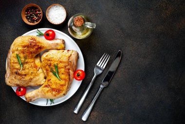 Çatal ve bıçakla tabakta kızarmış tavuk bacağı.