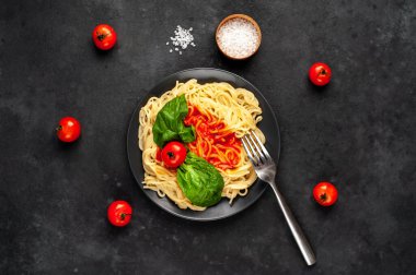 Fesleğen yaprakları ve kırmızı sosla servis edilen lezzetli makarna.